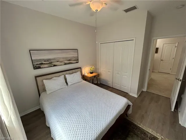 Bedroom with wood finished floors, a closet, and a ceiling fan