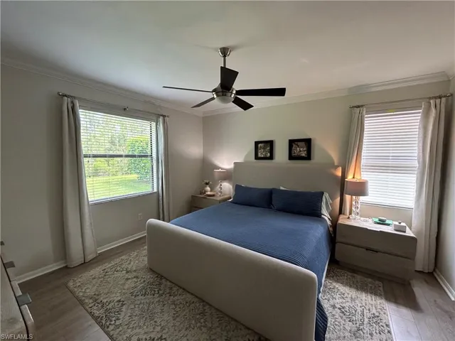 Bedroom with crown molding, light wood-type flooring, and ceiling fan