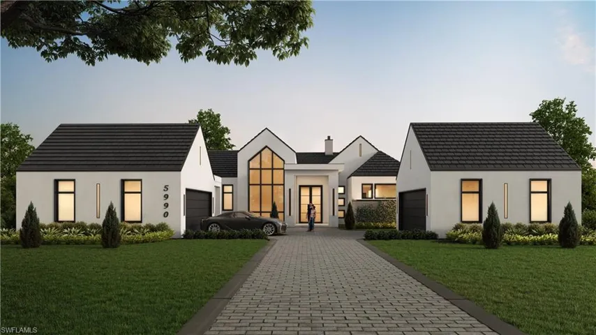 View of front of property with a lawn, stucco siding, decorative driveway, and a garage