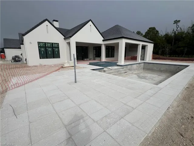 View of pool featuring patio surround, an empty pool, and a hot tub