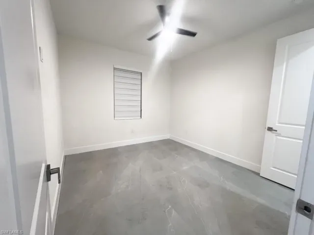 Spare room featuring finished concrete floors and a ceiling fan
