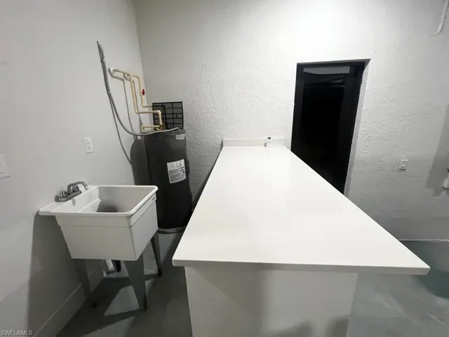Miscellaneous room with a textured wall and electric water heater