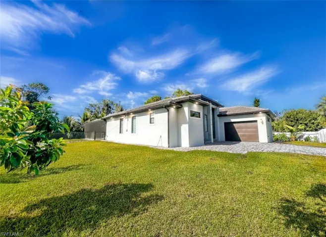 View of property exterior featuring stucco siding, a garage, and decorative driveway