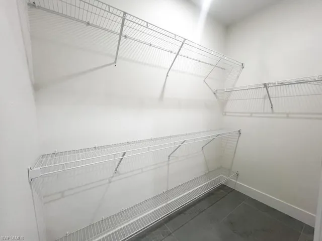 Walk in closet featuring dark tile patterned floors