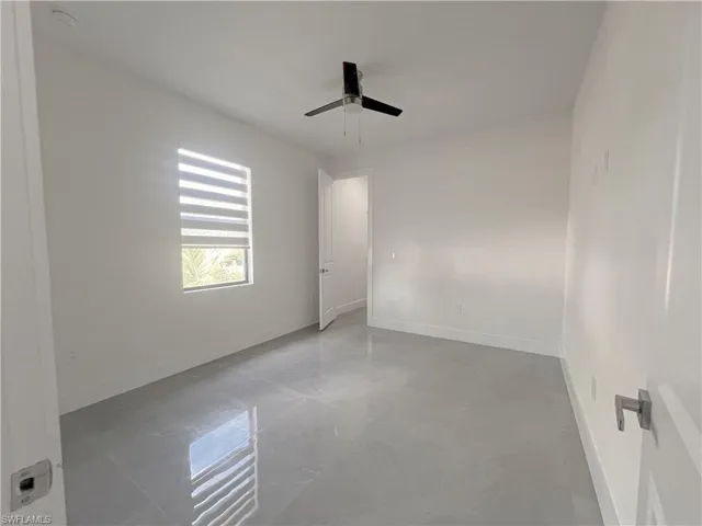 Unfurnished room with baseboards and a ceiling fan