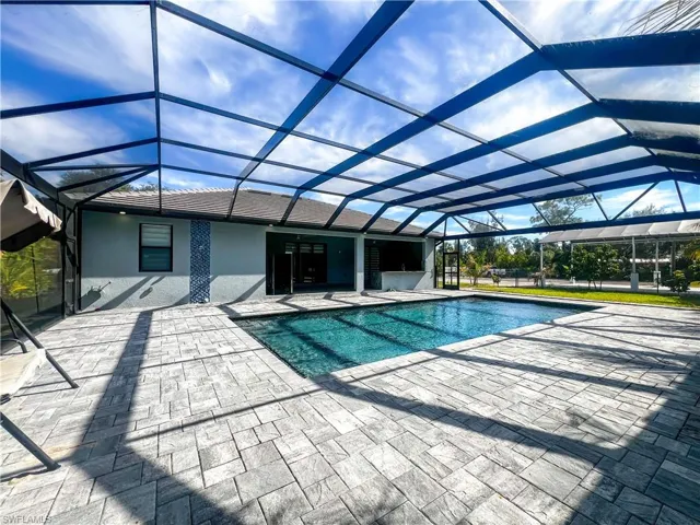 Outdoor pool with a sunroom, a lanai, and a patio