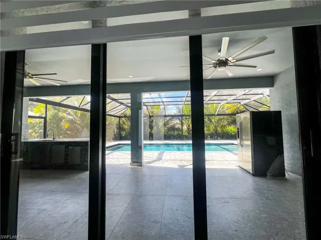 Outdoor pool featuring a ceiling fan and a sunroom