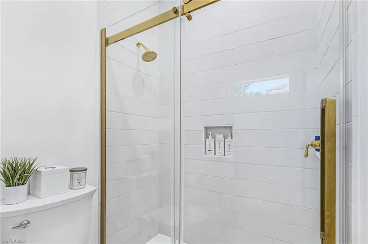 Full bathroom with toilet and a stall shower