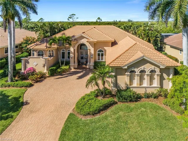 Mediterranean / spanish-style home featuring stucco siding, decorative driveway, a tiled roof, a front yard, and french doors