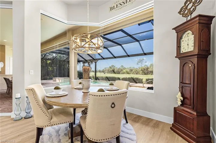 Dining area with light wood-style floors and a sunroom