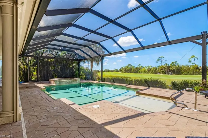 Combined pool / hot tub featuring a lanai, a patio, a sunroom, and view of golf course