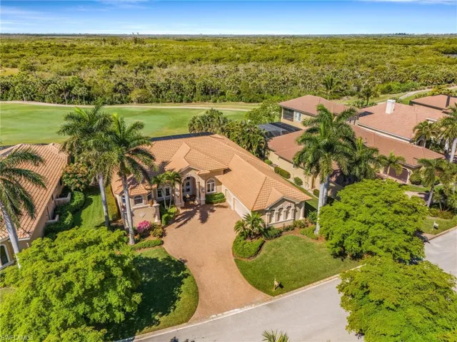 View from above of property featuring a heavily wooded area and a golf club