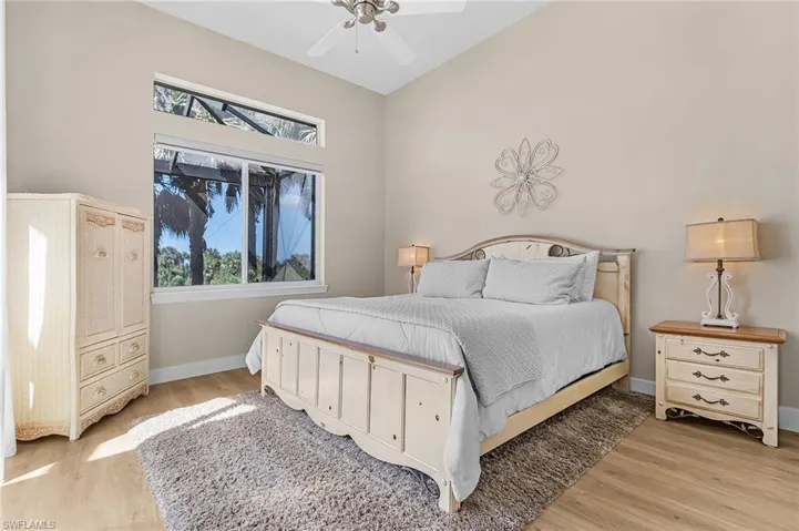 Bedroom featuring light wood finished floors, ceiling fan, and vaulted ceiling