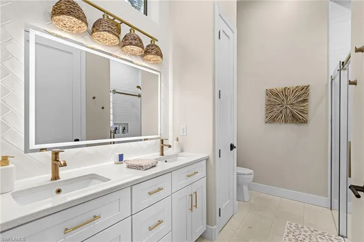 Full bath with double vanity and a stall shower