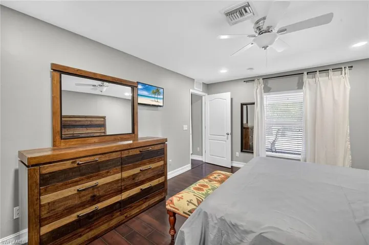 Bedroom with dark wood-style flooring, a ceiling fan, and recessed lighting