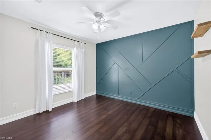 Spare room with dark wood-style floors and ceiling fan
