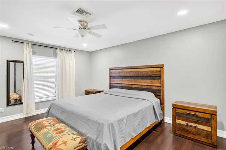 Bedroom with dark wood-style floors, recessed lighting, and ceiling fan