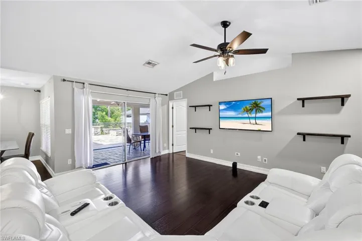 Living area with wood finished floors, lofted ceiling, and ceiling fan