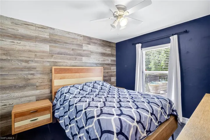 Bedroom featuring wooden walls and a ceiling fan