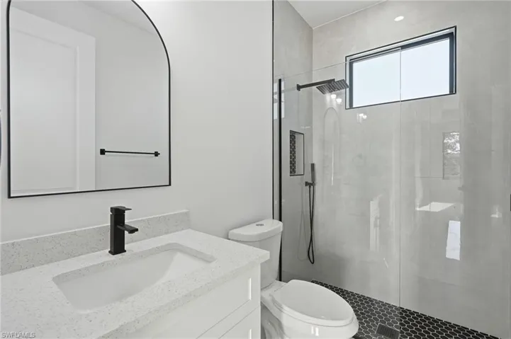 White vanity with an integrated sink and light-colored countertop
