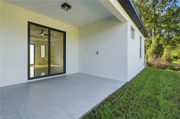 Modern covered patio featuring polished concrete flooring, seamlessly connecting the residence to the landscaped grounds