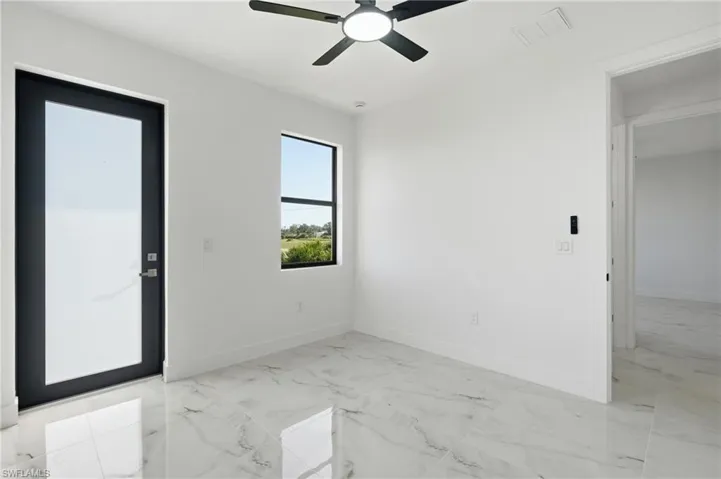 White walls, glossy tile flooring, black ceiling fan, and a black-framed window