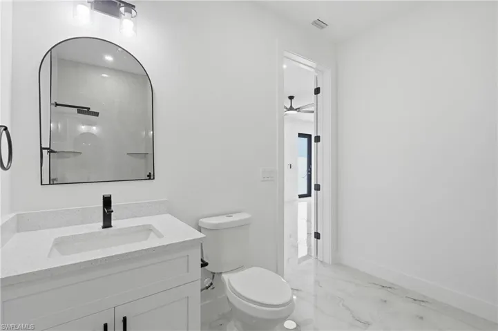 White vanity with a quartz countertop and integrated rectangular sink