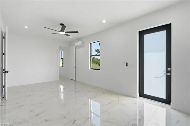 Spacious room with polished tile flooring, recessed lighting, and a modern ceiling fan