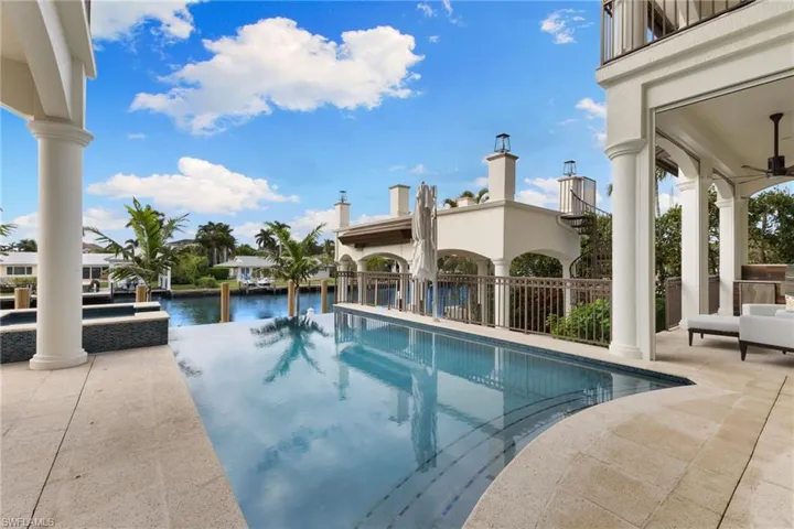 Infinity edge pool during the day with the boathouse in the background