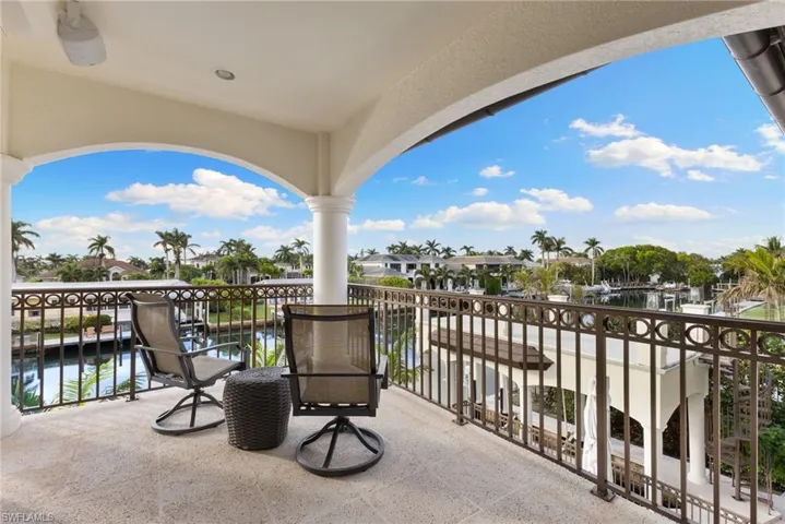 Media room and guest suite balcony featuring pool, water, and sunset views