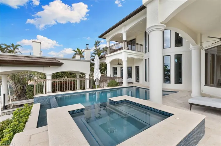 Infinity edge pool and waterfall hot tub during the day