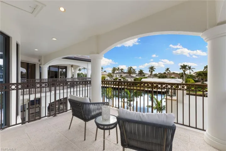 Guest suite balcony featuring pool, water, and sunset views