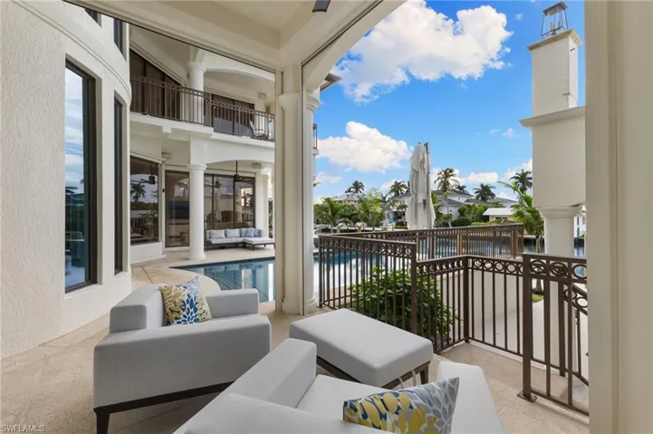 Primary bedrooms balcony with view of the pool and water