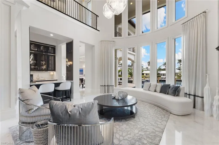 Living room featuring a high ceiling, an inviting chandelier, and full wet bar