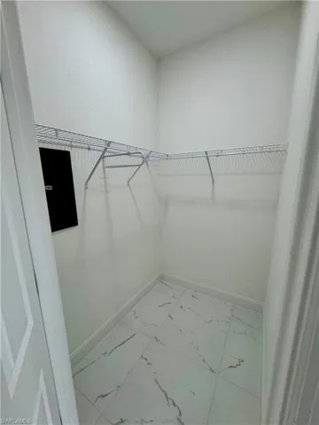 Walk in closet with light marble finish flooring