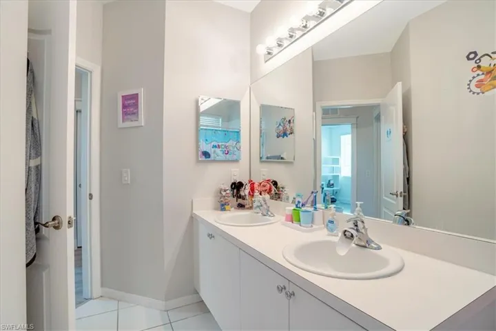 Bathroom featuring tile flooring, oversized vanity, and double sink