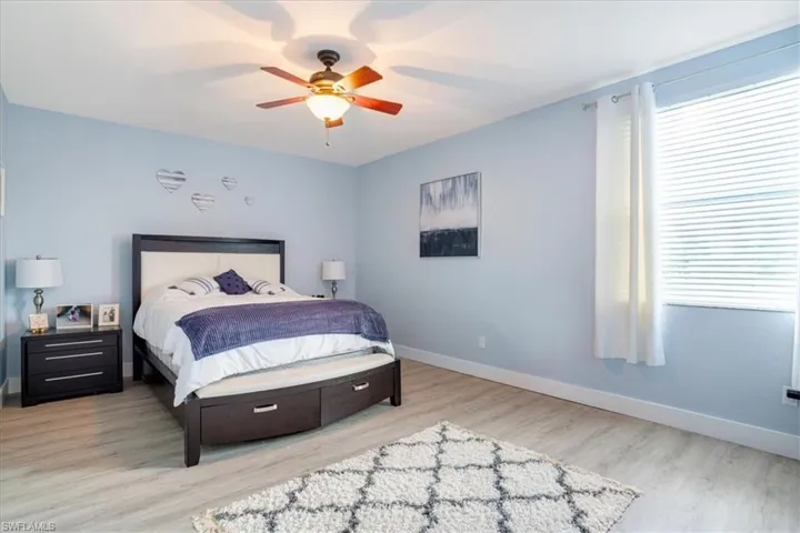 Bedroom with ceiling fan and light hardwood / wood-style flooring