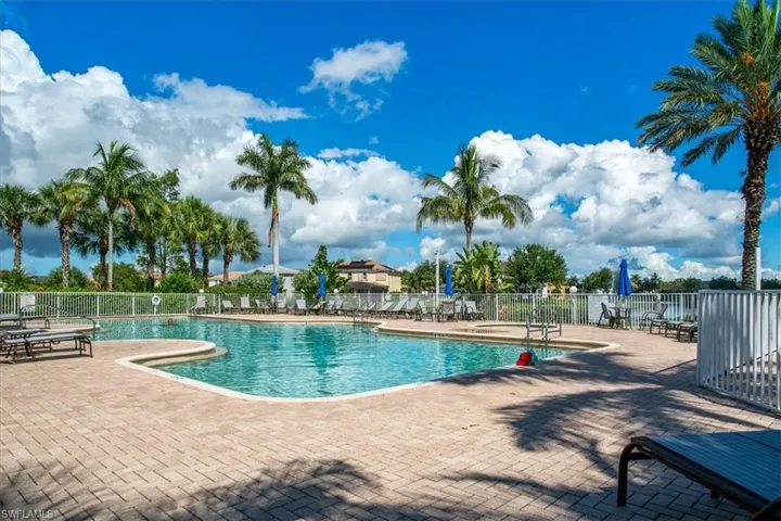 View of community swimming pool with a patio area at the clubhouse