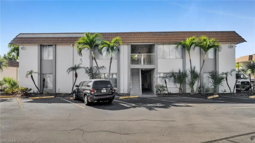 View of apartment building / complex featuring uncovered parking