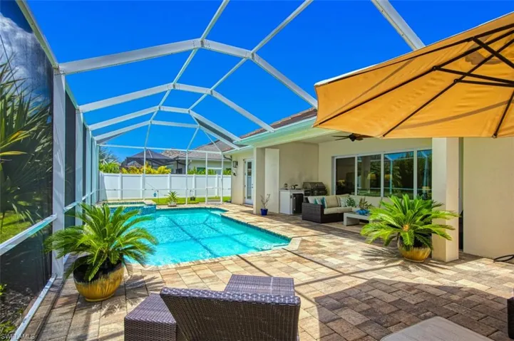 View of pool with outdoor lounge area, a patio, area for grilling, a lanai, and ceiling fan