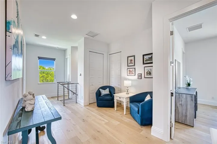 Living area featuring an upstairs landing, light wood-style floors, and recessed lighting