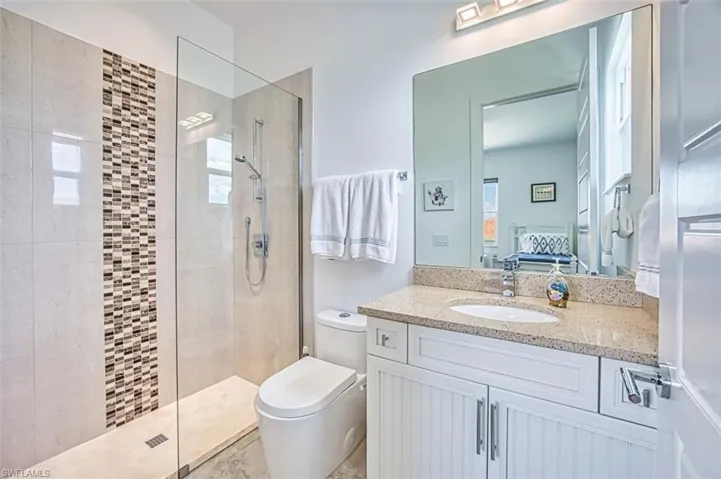 Full bath featuring ensuite bath, a walk in shower, vanity, and plenty of natural light