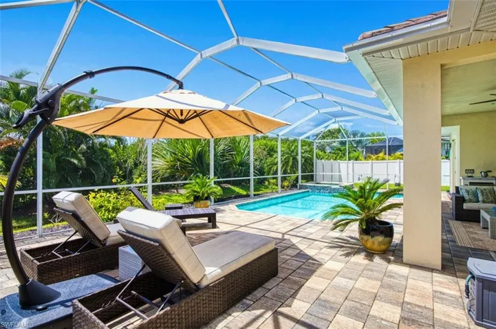 Outdoor pool featuring a patio area and glass enclosure