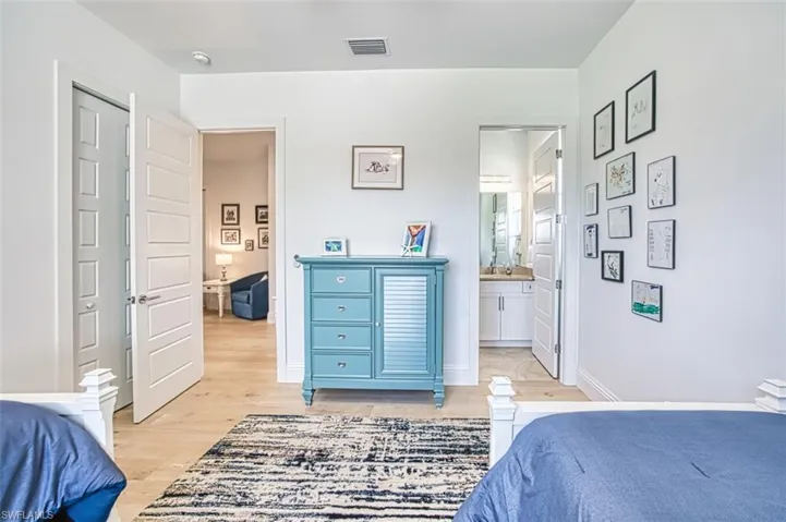 Bedroom with light wood finished floors and ensuite bath