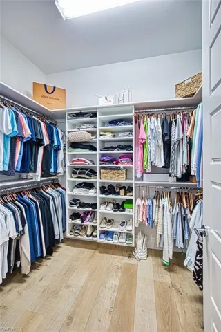 Spacious closet with hardwood / wood-style floors