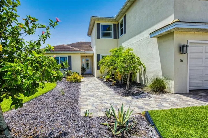 View of exterior entry with stucco siding and a garage
