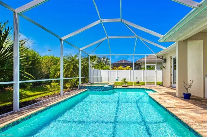 View of pool featuring a pool with connected hot tub, a lanai, and a patio area