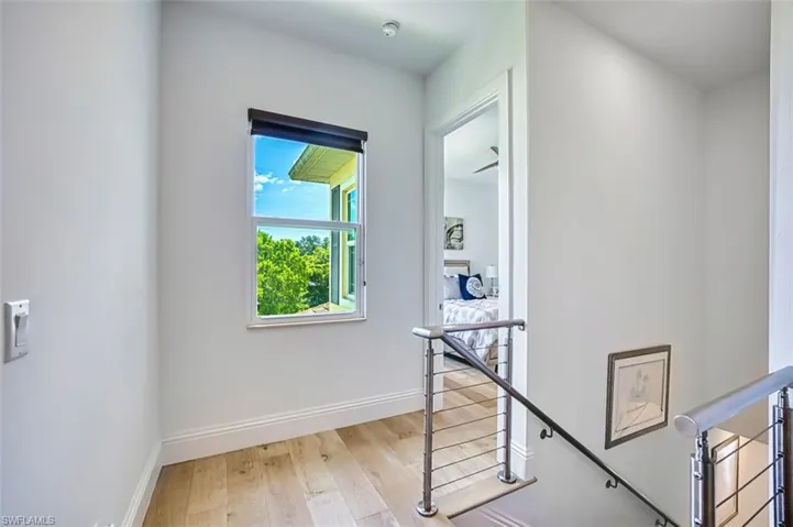 Hall with an upstairs landing and light wood-style floors