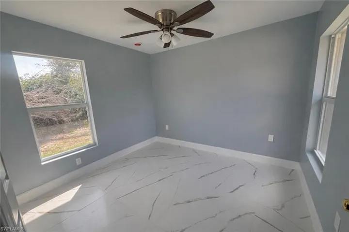 Unfurnished room featuring baseboards and ceiling fan