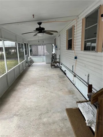 Unfurnished sunroom featuring ceiling fan